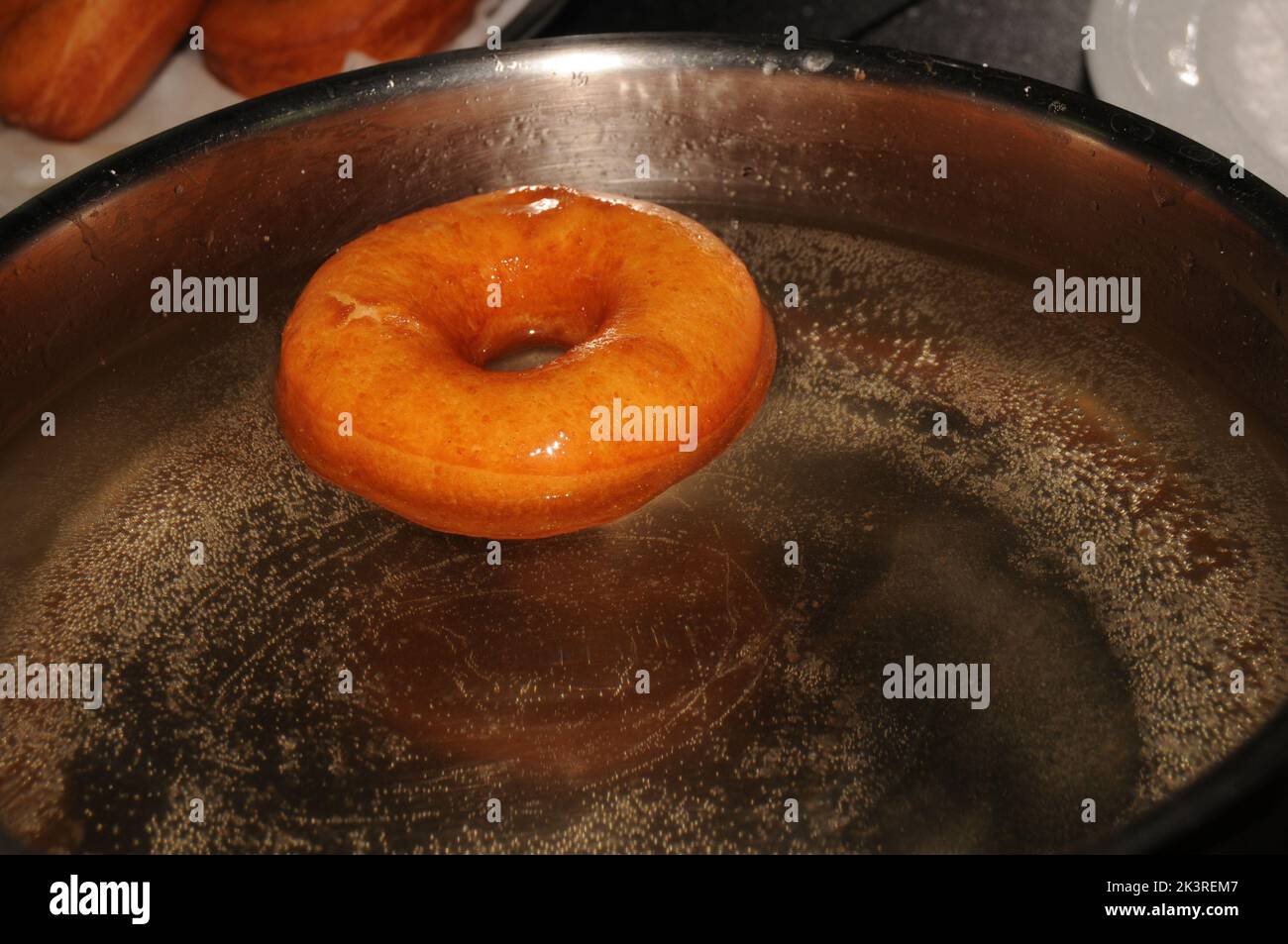 Elaboration of the traditional donuts, passed through syrup Stock Photo