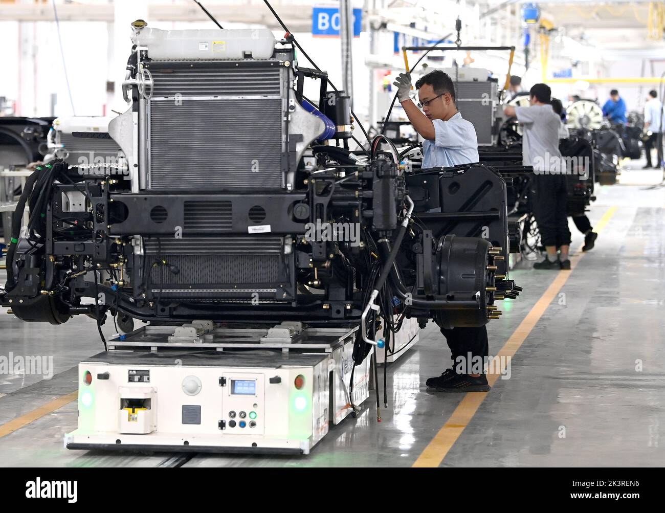 (220928) -- XI'AN, Sept. 28, 2022 (Xinhua) -- Employees work on the assembly line of the heavy truck capacity expansion project at the Shaanxi Automobile Holding Group in Xi'an, northwest China's Shaanxi Province, Sept. 27, 2022. Shaanxi Automobile Holding Group is a leading enterprise in equipment manufacturing in Shaanxi Province.   Since the beginning of this year, the overseas orders of Shaanxi Automobile have continued to grow. The heavy trucks produced here are exported to more than 130 countries and regions.    An expansion project is put into production recently to boost the capacity. Stock Photo