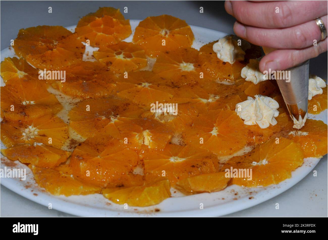 Juicy orange slices, flavored with sugar and cinnamon and fresh cheese Stock Photo