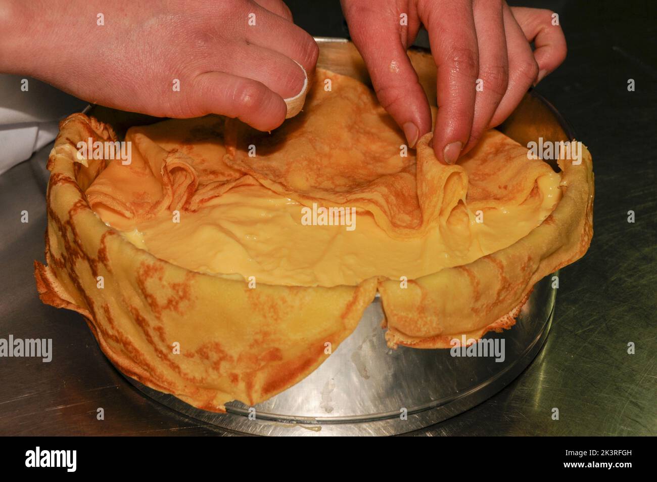 Elaboration of the orange crepe cake. Delicious breakfast Stock Photo