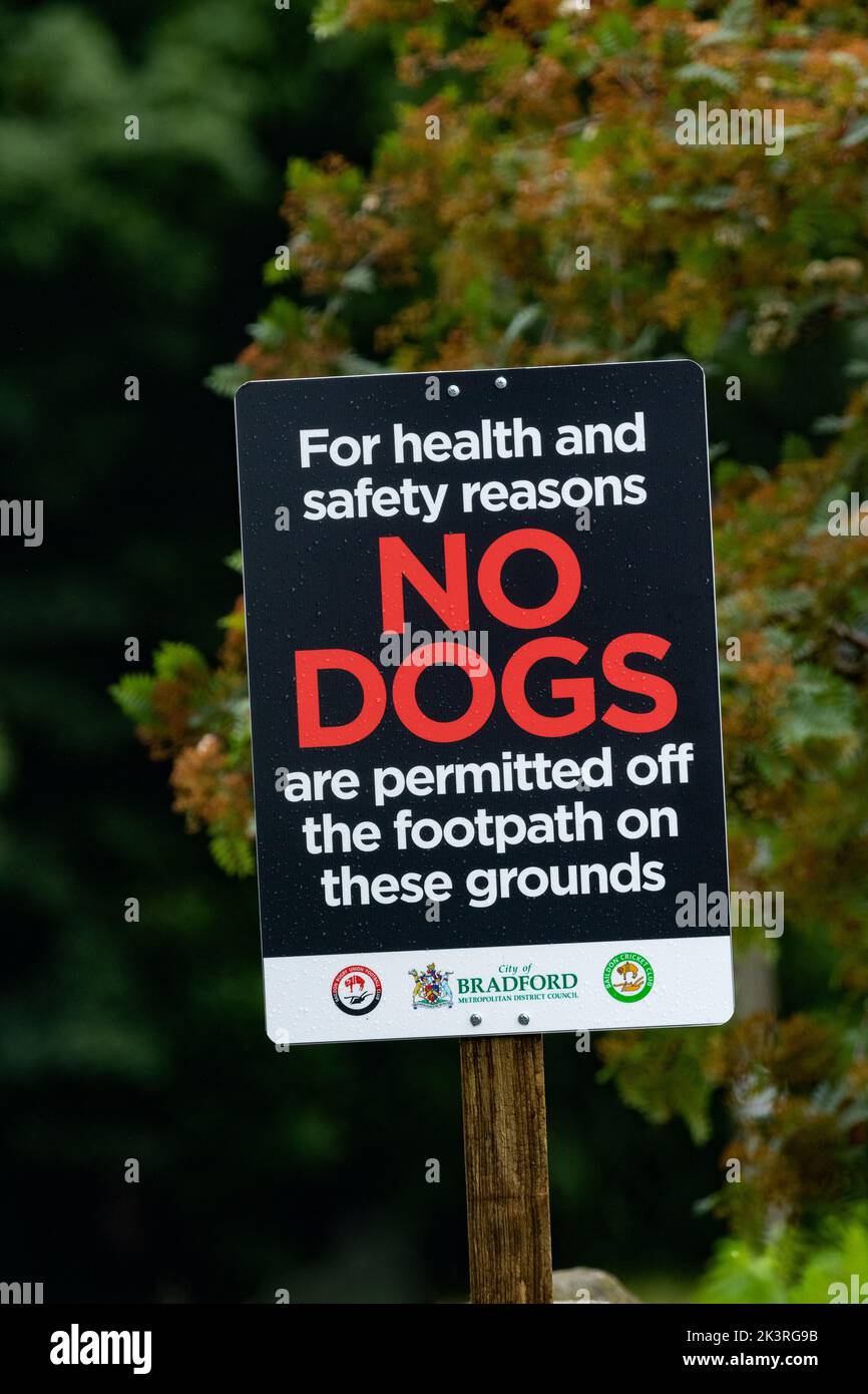 A 'No Dogs' sign next to playing fields in Bradford, Yorkshire, Stock Photo