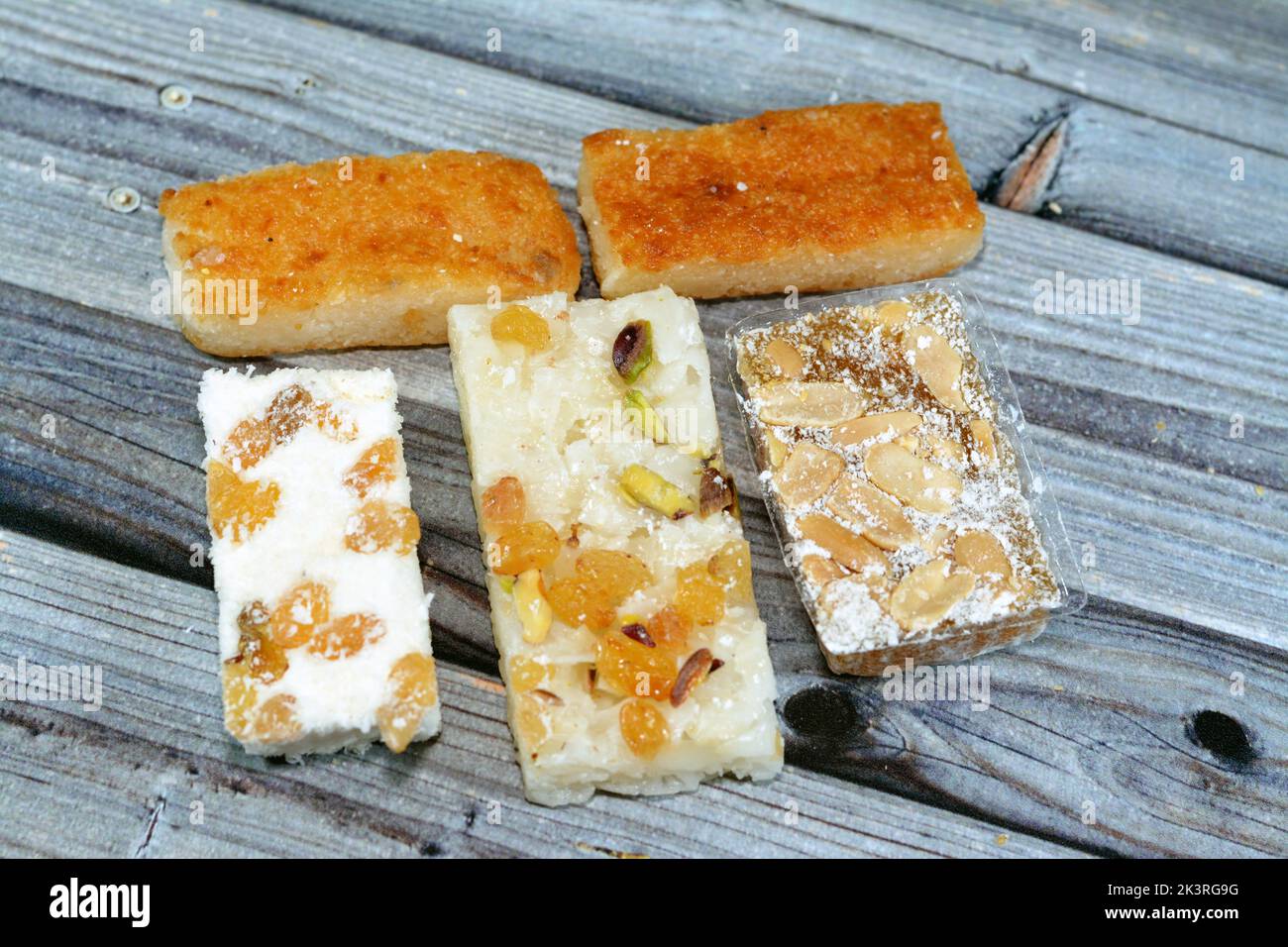 Various Eastern candy of taffy with peanuts, raisins and coconut and bassima as a celebration of the prophet's Mohamed birthday in Egypt, Arabian and Stock Photo
