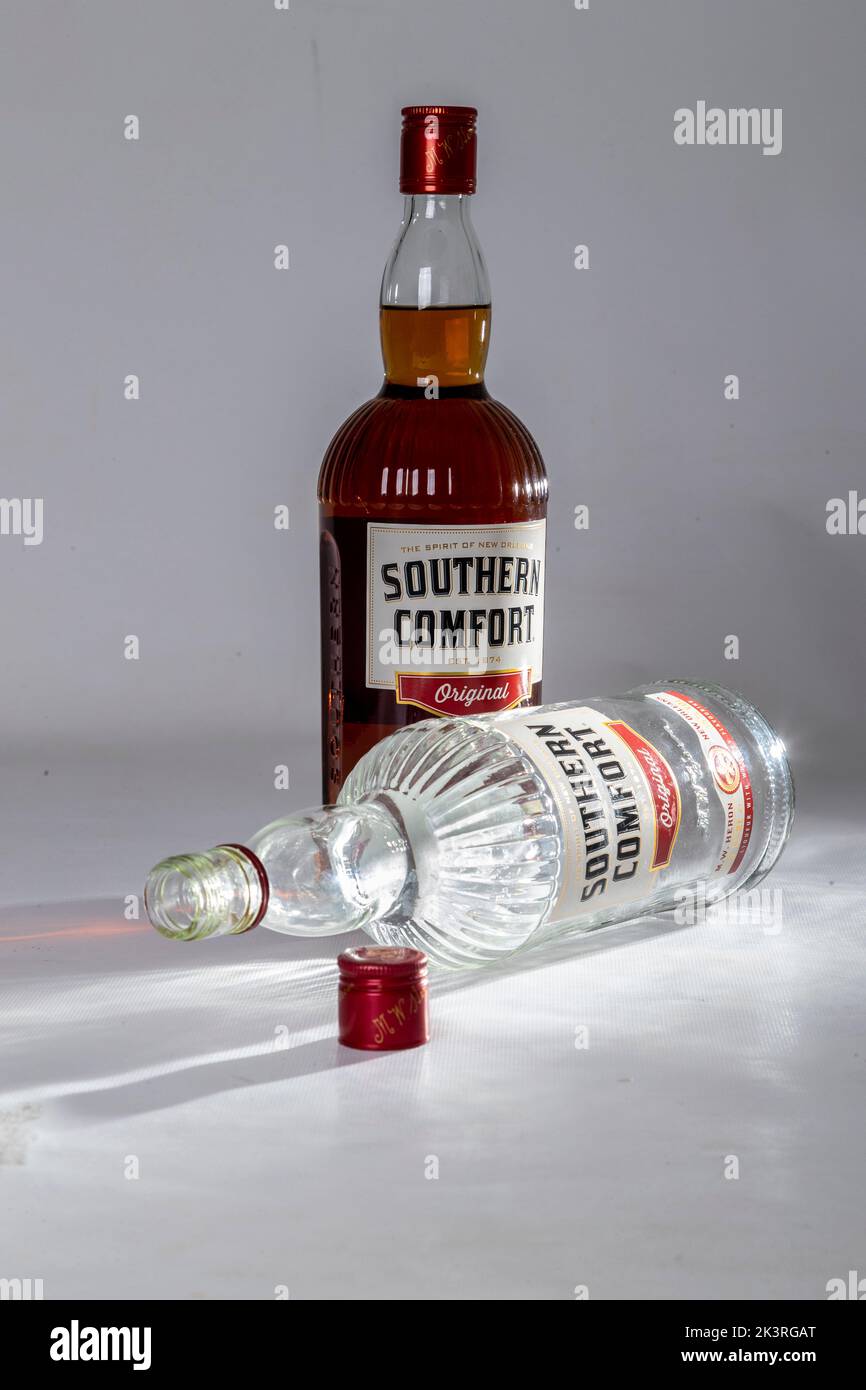 Studio shot of a full and empty bottle of Southern Comfort on a plain background. Stock Photo