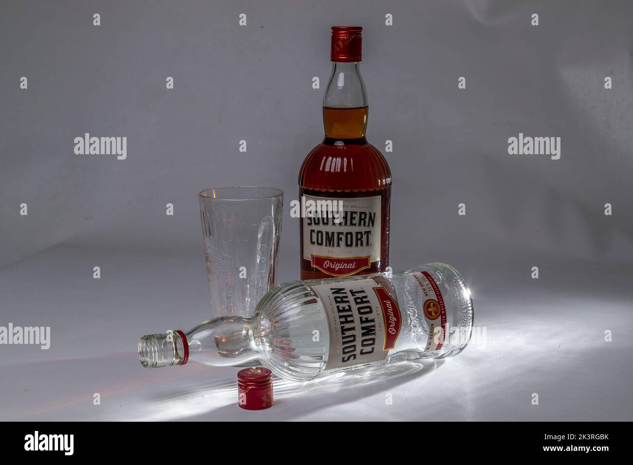 Studio shot of a full and empty bottle of Southern Comfort on a plain background. Stock Photo