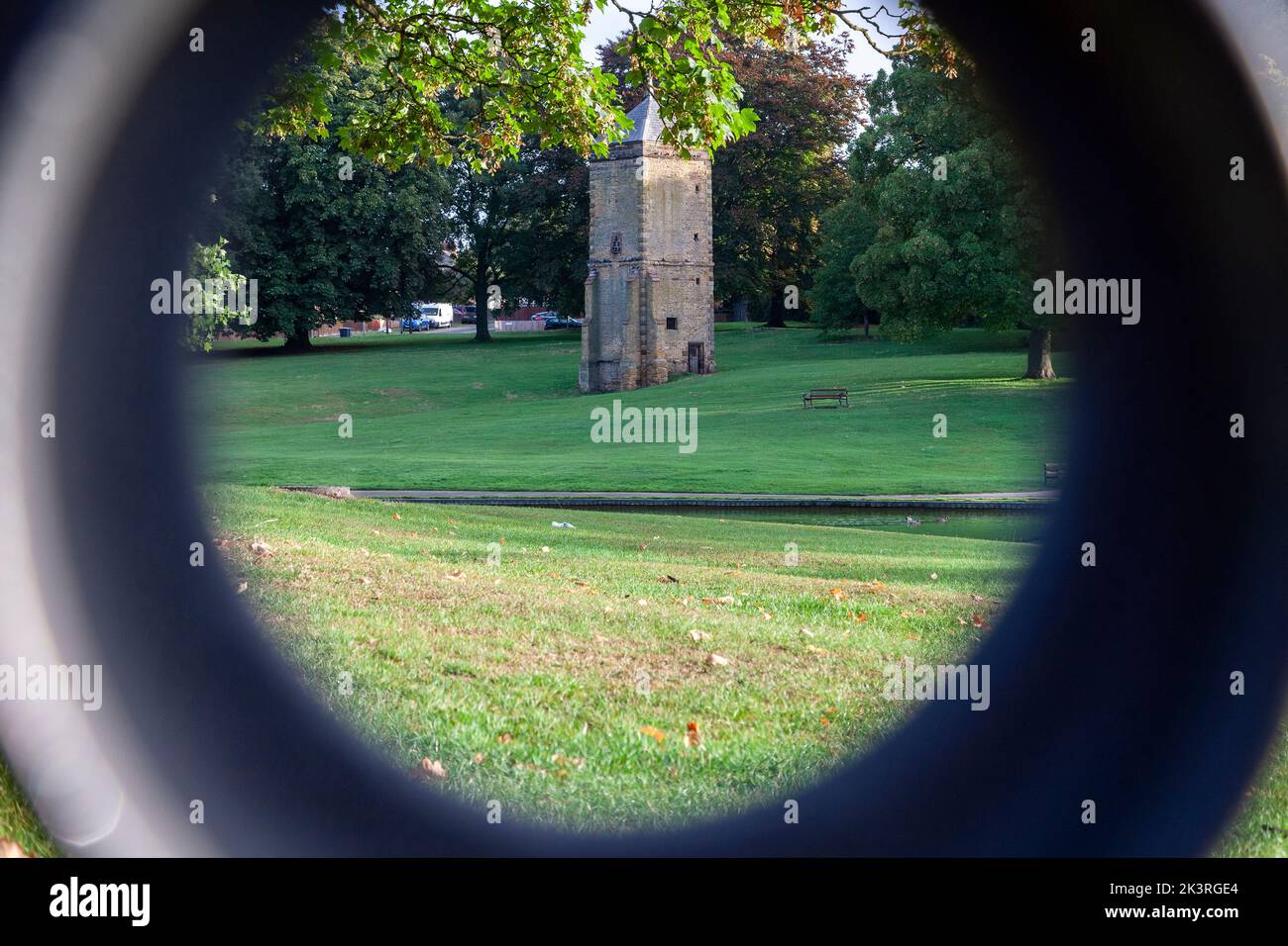 Unusual, viewpoint of Abington Park looking through the ironwork on the end of a bench. Northampton, England, UK. Stock Photo