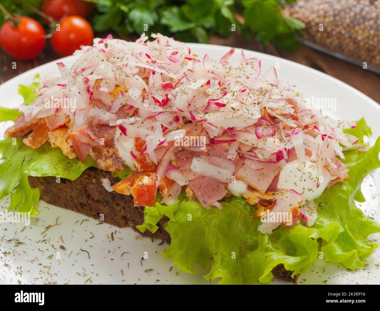Smerrebred with bacon, scrambled eggs and radishes Stock Photo