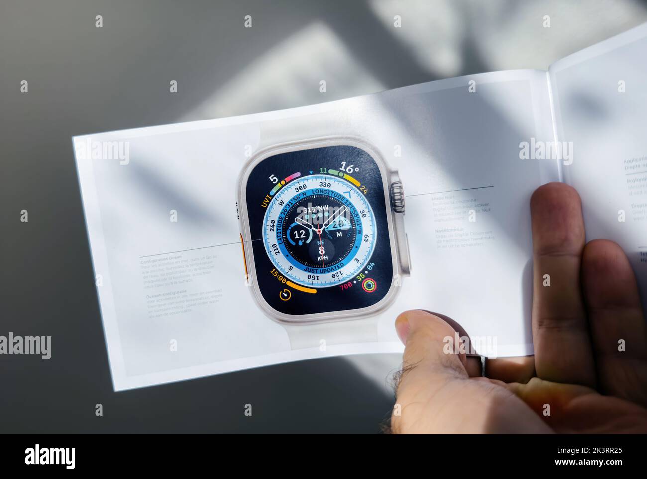 London, United Kingdom - Sep 27, 2022: POV male hand holding the marketing material of the new Apple Watch Series Ultra designed for extreme activities like endurance sports, elite athletes Stock Photo