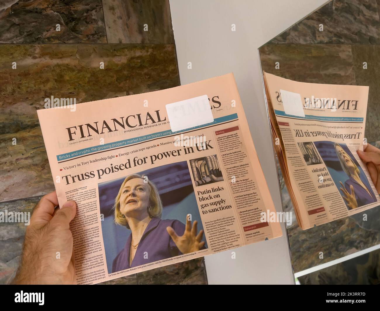 London, United Kingdom - Sep 6, 2022: Male hand holding reading latest Financial Times newspaper featuring new Prime Minister of the United Kingdom Liz Truss - reflection in mirror Stock Photo
