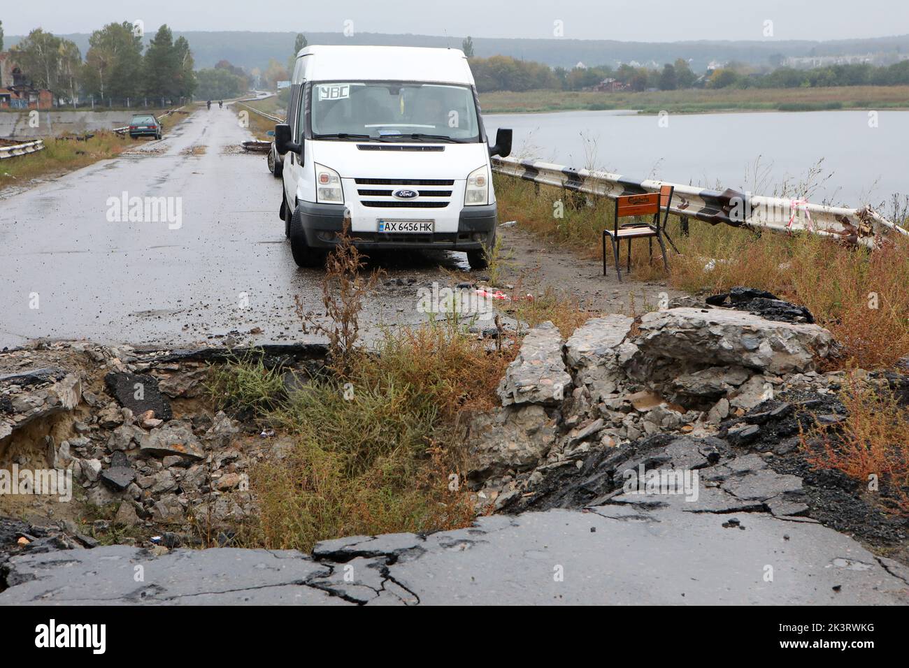 KHARKIV REGION, UKRAINE - SEPTEMBER 27, 2022 - A van is parked at a crater on the bridge across the Pechenihy Reservoir that was destroyed by Ukraine' Stock Photo