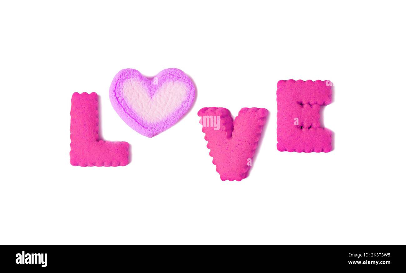 The word LOVE spelled with magenta alphabet cookies and lavender marshmallow candy on white background Stock Photo