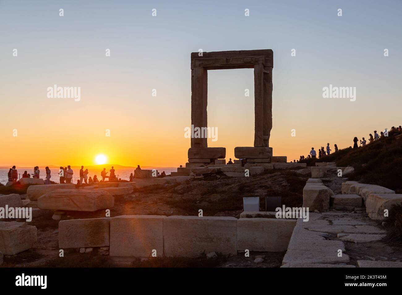 Naxos island, sunset over Temple of Apollo, Cyclades Greece. People enjoys the sundown from the islet of Palatia. Stock Photo