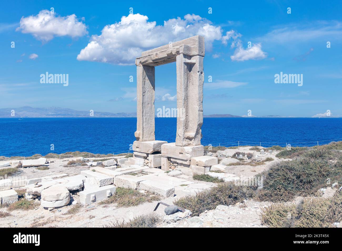 Naxos island, Temple of Apollo, Cyclades Greece. Portara, marble pillars gate, sunny day, calm sea, blue sky background. Summer archeology destination Stock Photo