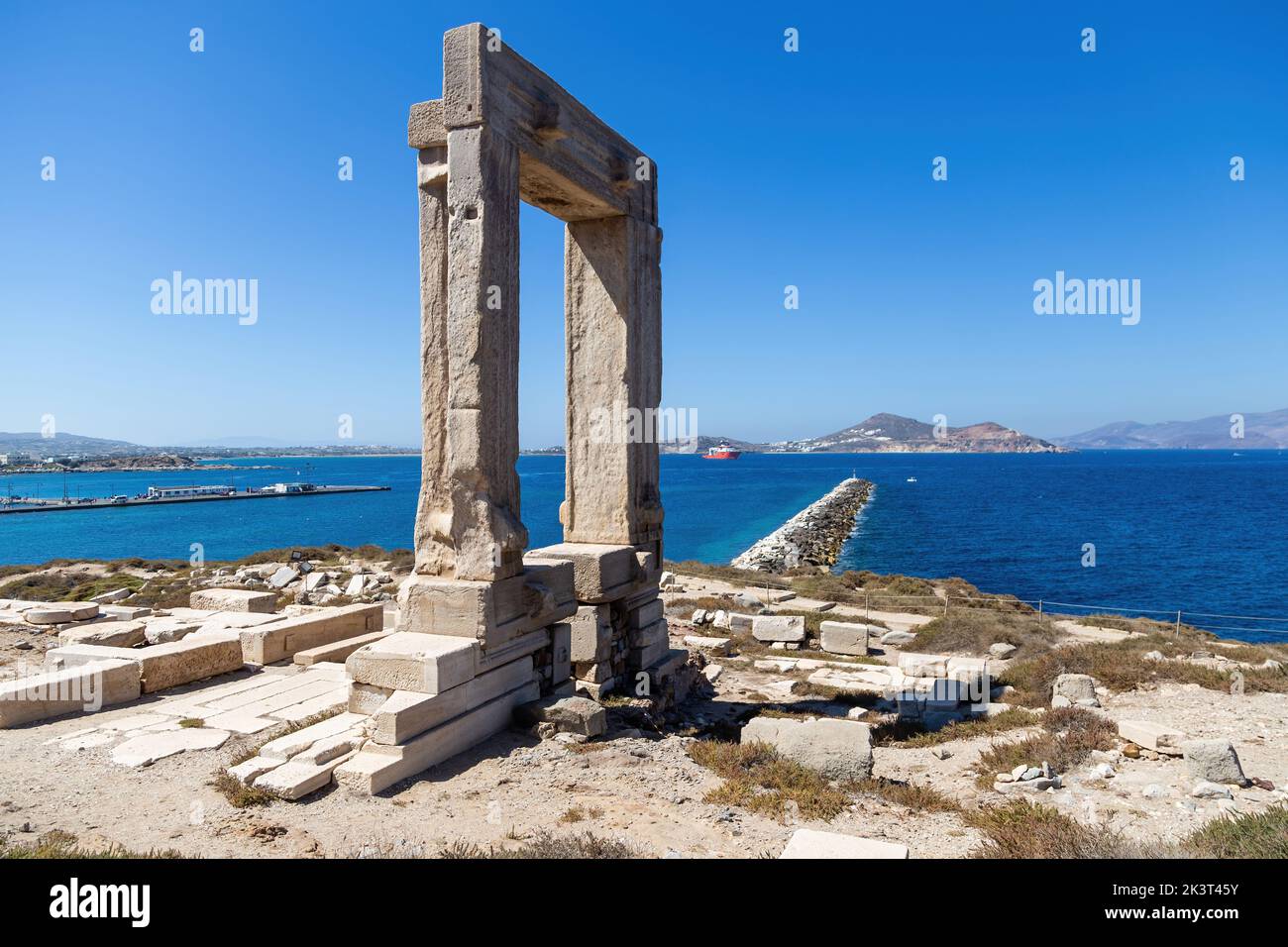 Naxos island, Temple of Apollo, Cyclades Greece. Portara, marble pillars gate on islet of Palatia, sunny day, calm sea, harbor, blue sky Stock Photo