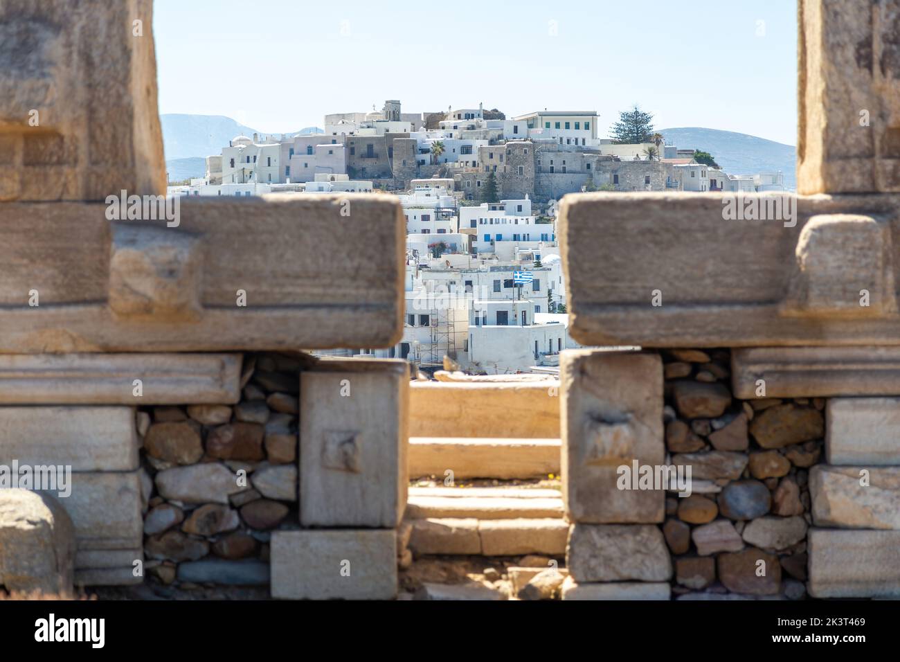 Naxos island, Greece. Chora traditional buildings, view through Portara, the marble pillars gate of Apollo Temple Stock Photo