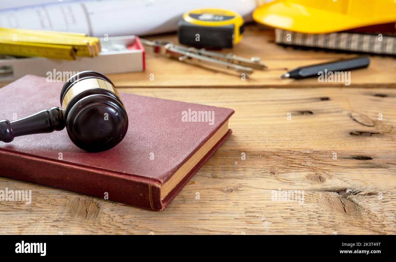 Construction and Labor law. Judge gavel and engineering tools on wooden table, close up view. Stock Photo
