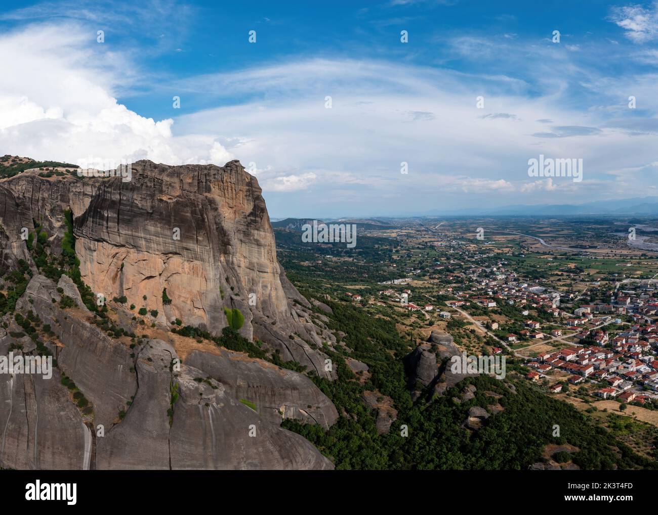 Meteora Greece at sunrise, Blue sky with clouds over Monastery buildings on top of rocks and Kalambaka town and valley. Europe travel destination Stock Photo