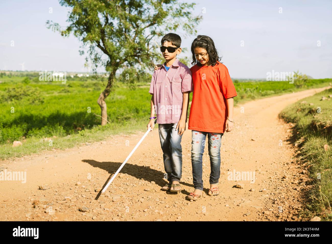 Teenager girl helping to blind brother by walking each other at mountain - concept of caregiver,friendship bonding and disability. Stock Photo