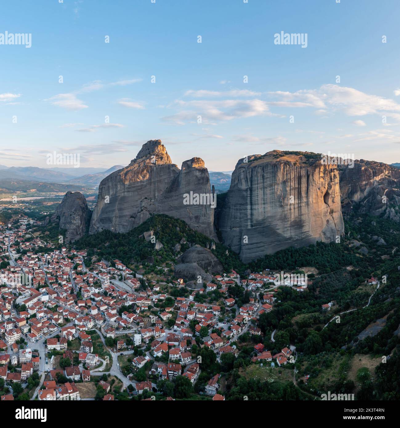 Meteora Greece at sunrise, Blue sky with clouds over Monastery buildings on top of rocks and Kalambaka town and valley. Europe travel destination Stock Photo