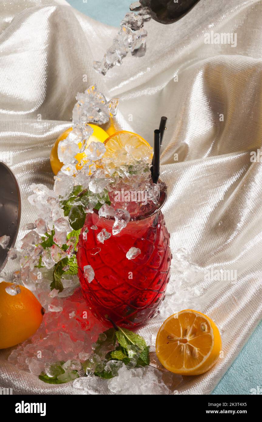 Glass of campari with soda, slice of lemon and ice cubes on white table.  Red drink still life. Sunny day, blurry background Stock Photo - Alamy