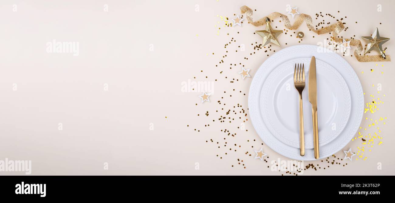 Table setting banner with golden cutlery on the beige table, Christmas or new year card or menu template copy space flat lay Stock Photo