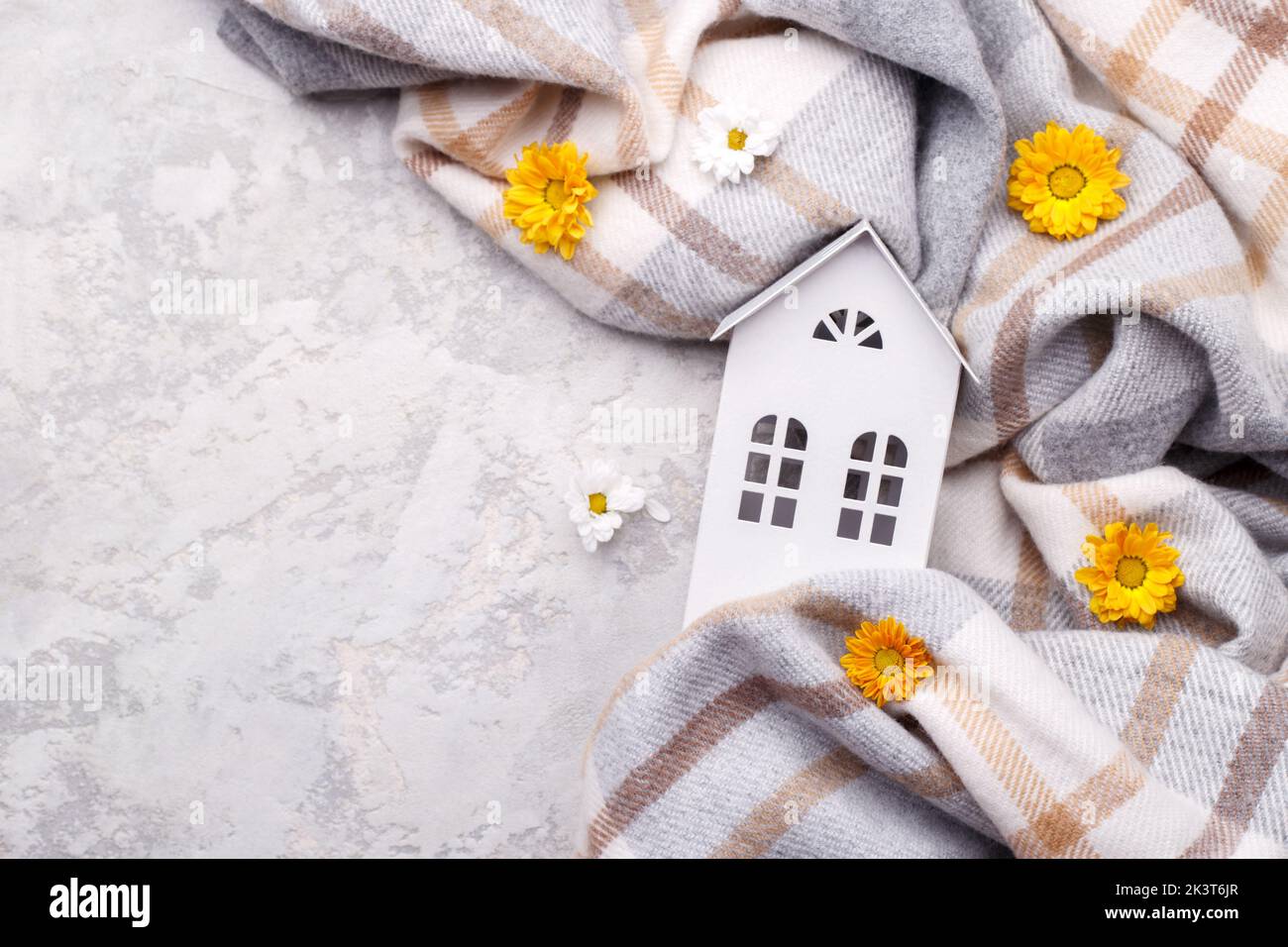 White toy house and yellow flowers on the plaid, autumn cozy concept, horizontal Stock Photo