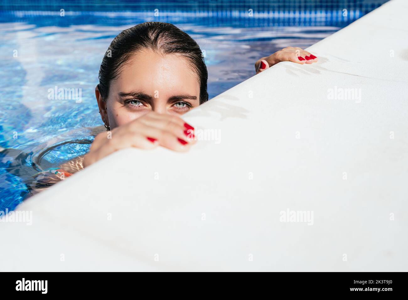 Pool Side Positive Image High angle of positive young female traveler enjoying fresh clear water ...