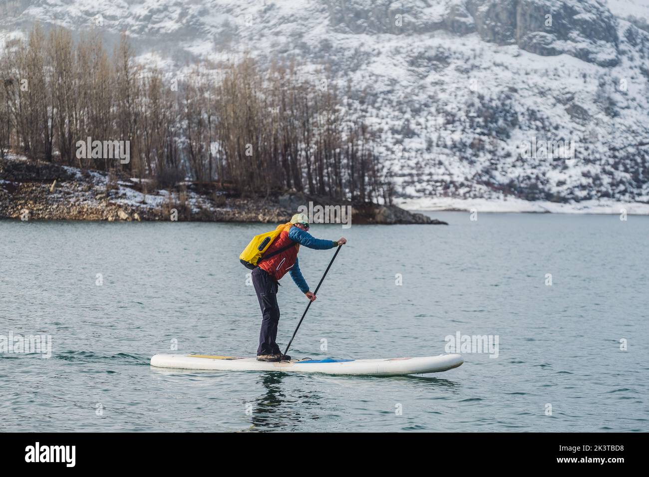Tourist floating on sup between water surface and picturesque view of