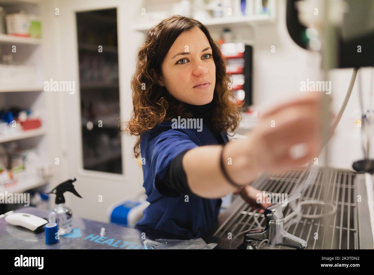 Young female doctor in uniform using medical equipments medical casein room on blurred background Stock Photo
