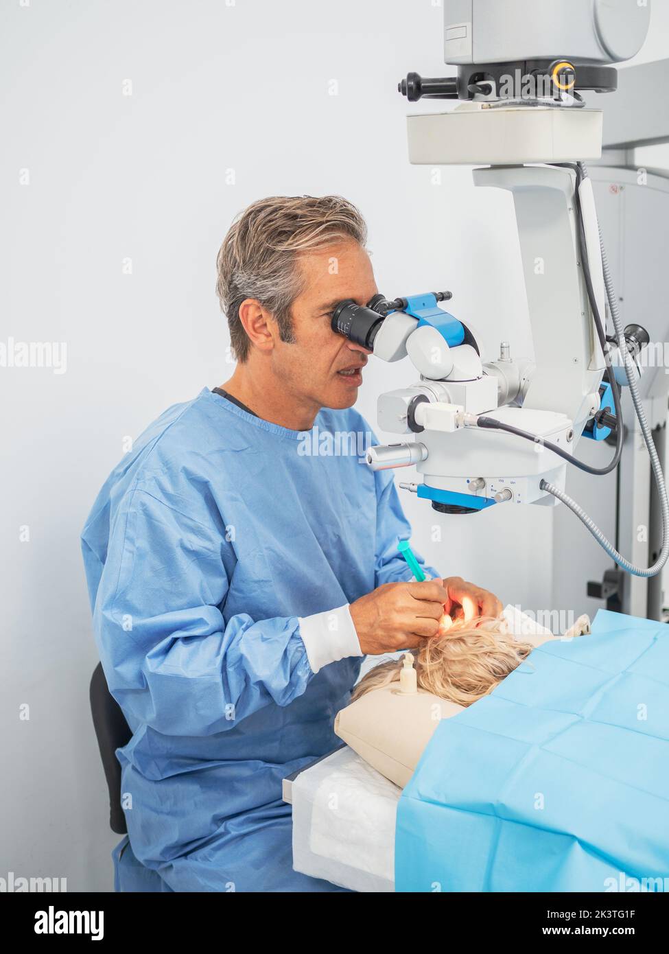 Animal surgeon using operating microscope while injecting medicine into