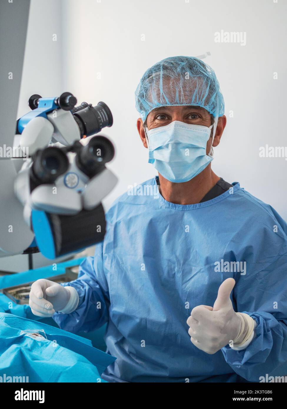 Adult man in medical uniform and mask looking at camera and showing ...
