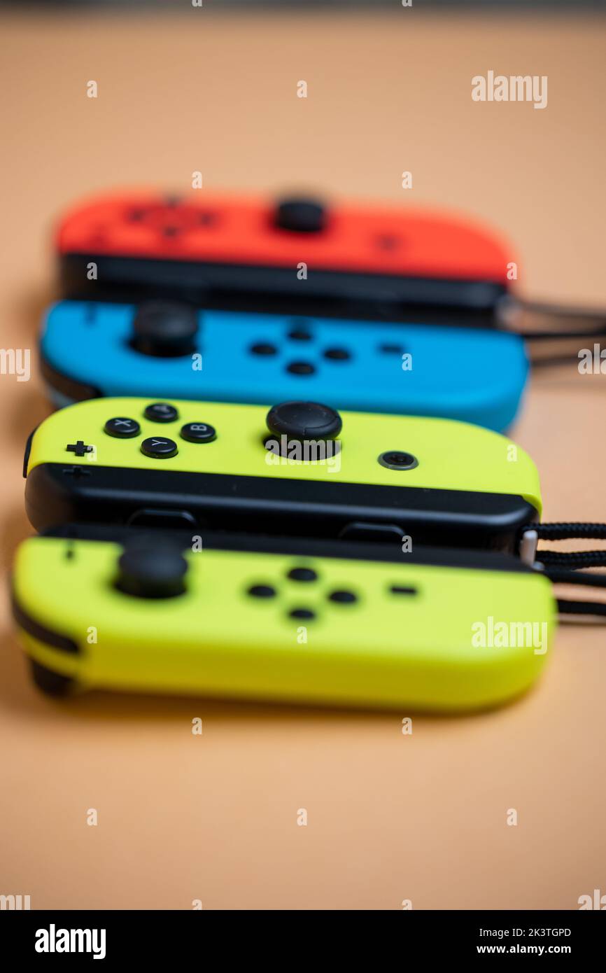 Nintendo Switch JoyCons aligned in a row. Yellow blue and red JoyCons