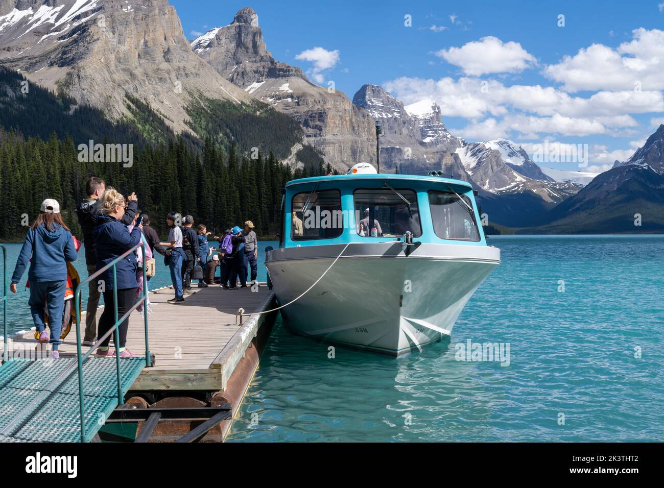 Jasper, Alberta, Canada - July 13, 2022: Tourists line up on the dock to board a boat ride as they depart from Spirit Island on Maligne Lake Stock Photo