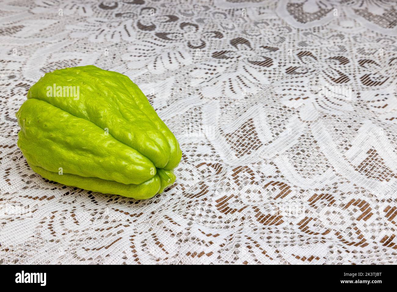 Brown Labu Front view of chayote with its stem on table with fine brown knit ...