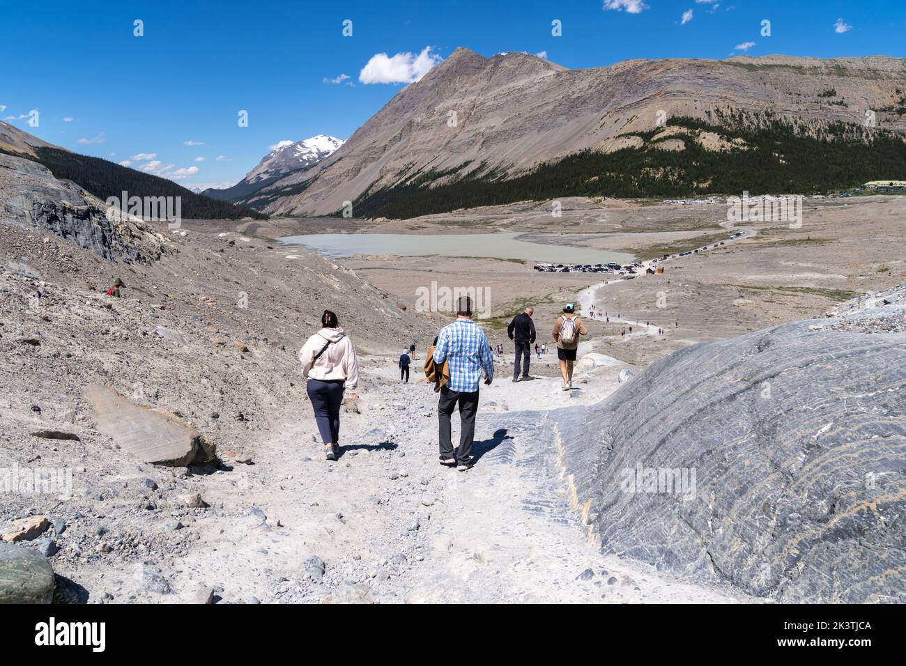 Alberta, Canada - July 12, 2022: Tourists walk down the trail from visiting the Athabasca Glacier at the Columbia Icefields Stock Photo