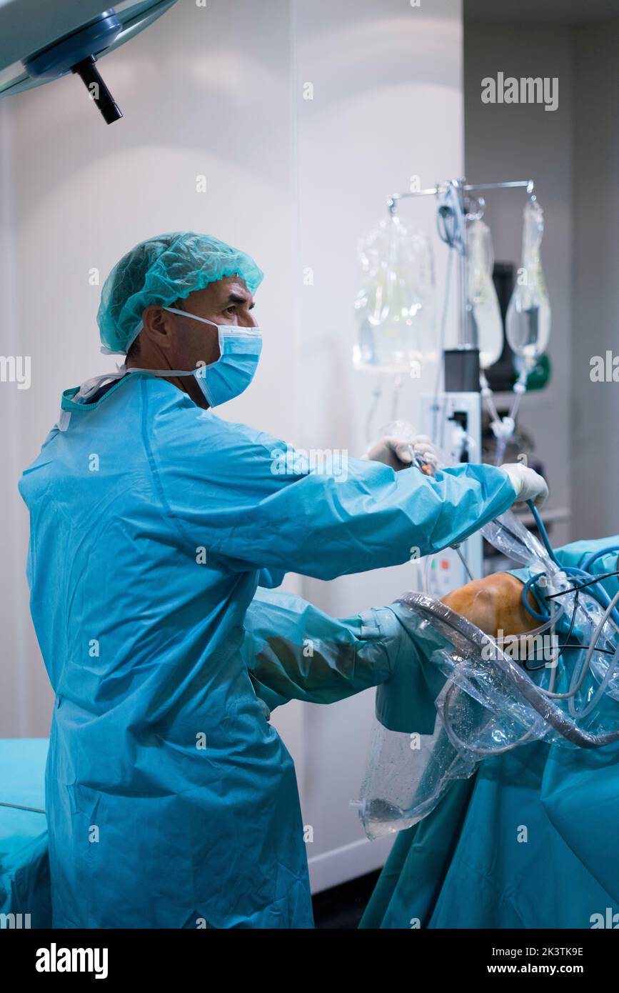 Side view of man in surgeon uniform looking away while conducting