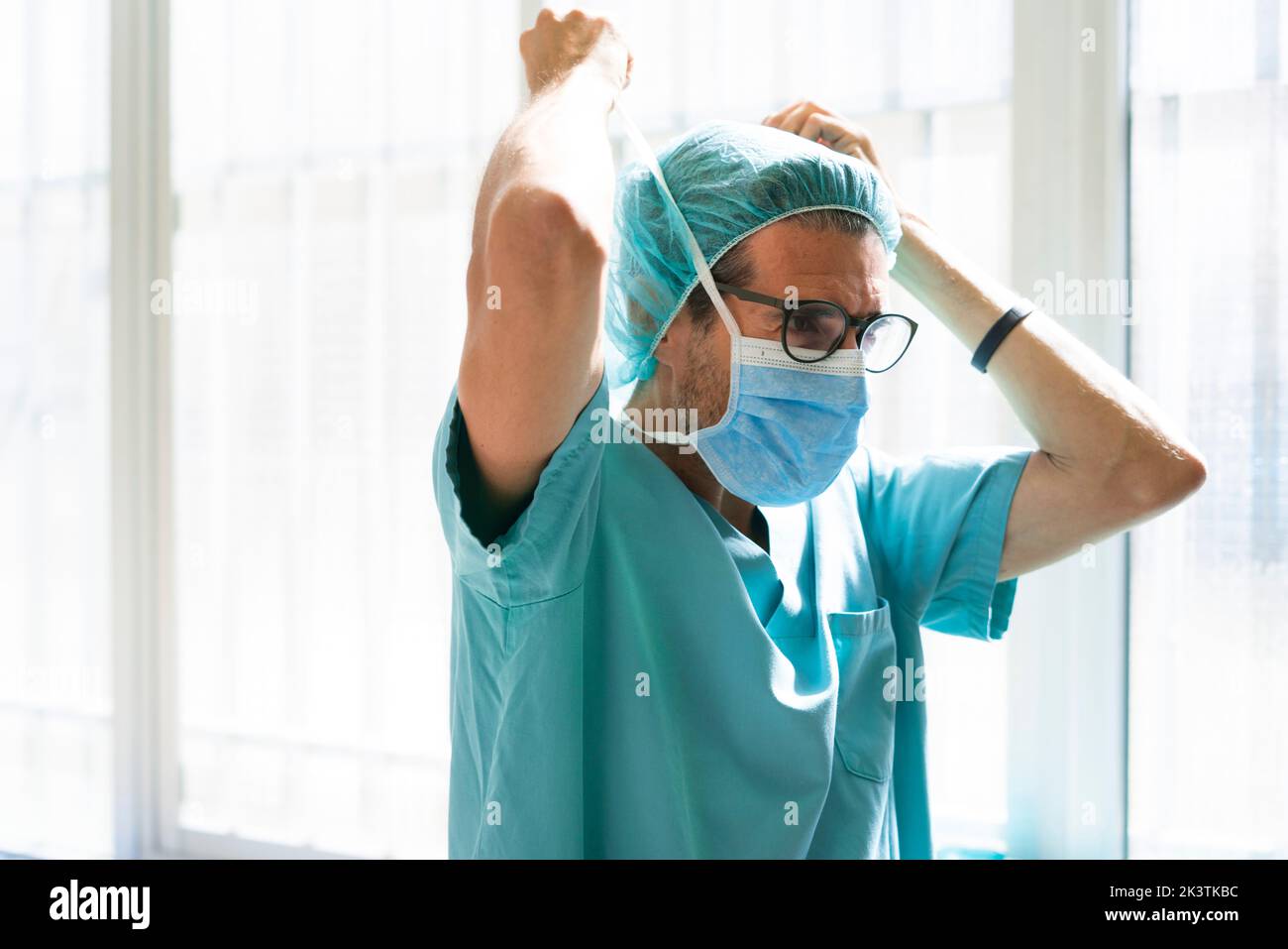 Surgeon putting on mask Stock Photo - Alamy