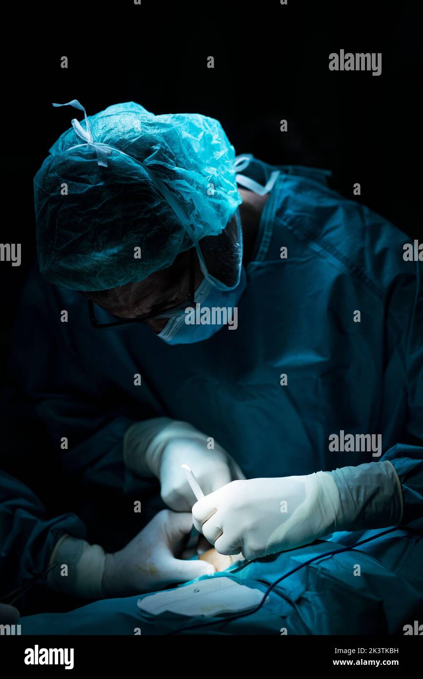 Surgeons conducting surgery on patient Stock Photo