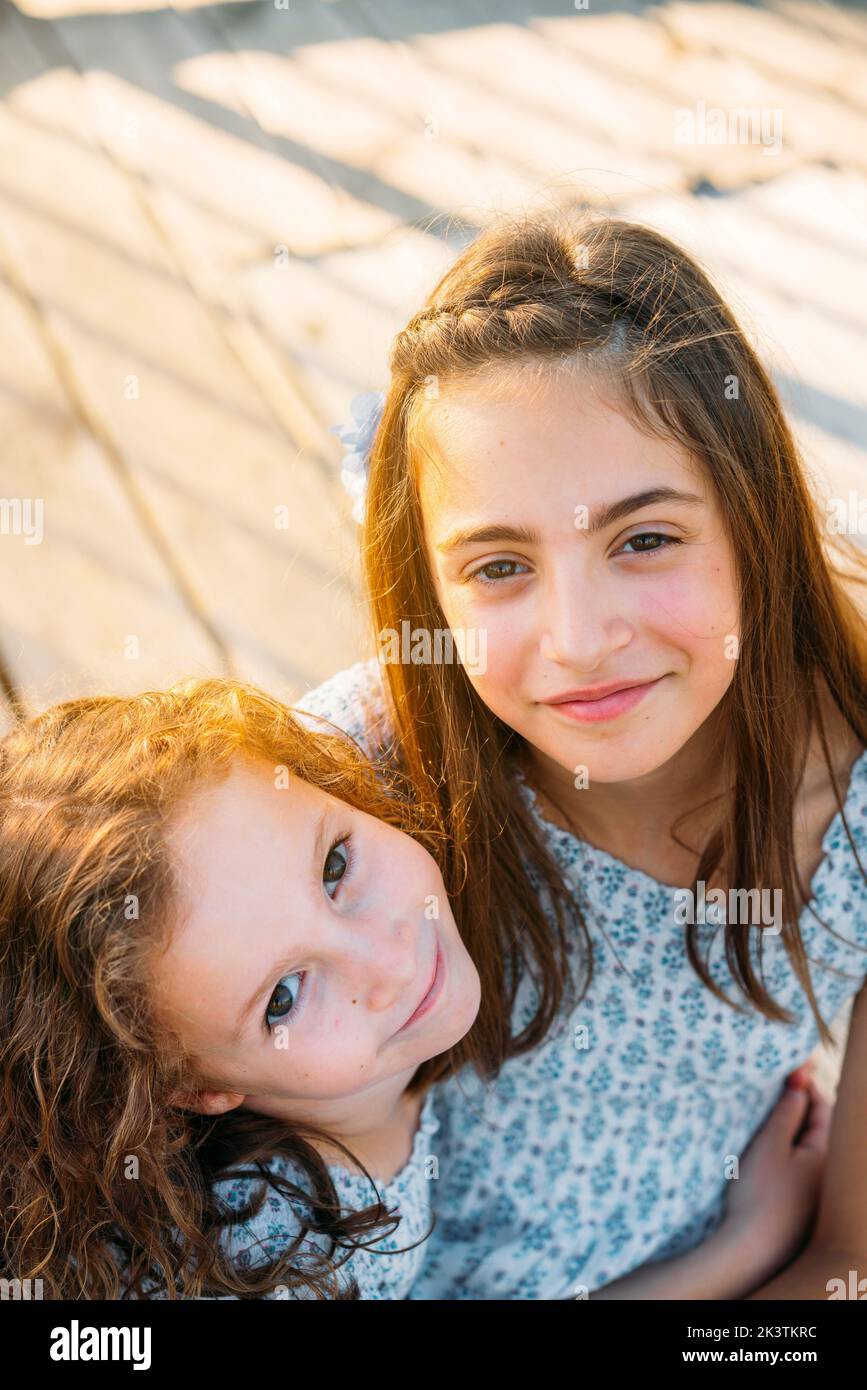 Girls sitting on wooden floor Stock Photo - Alamy