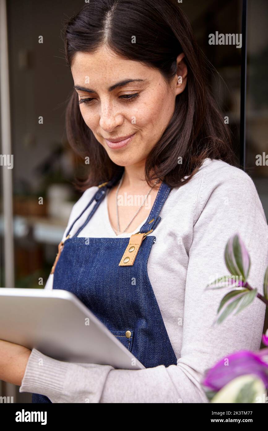 Garden center female owner using digital tablet Stock Photo