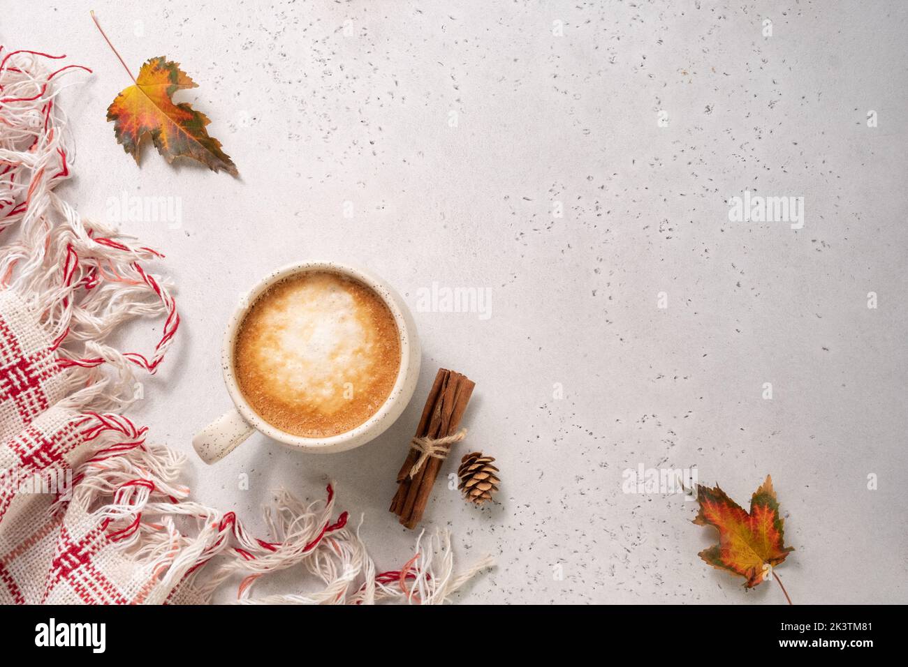 Autumn composition. Cup of coffee, blanket, autumn leaves, cinnamon sticks on white background. Stock Photo