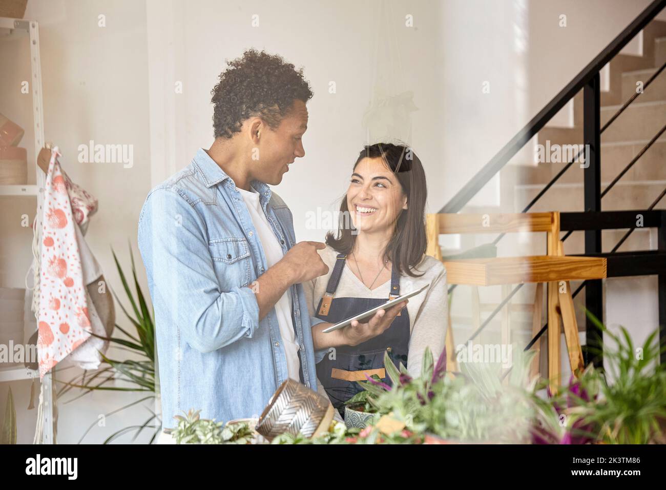 Greenhouse workers discussing over digital tablet Stock Photo