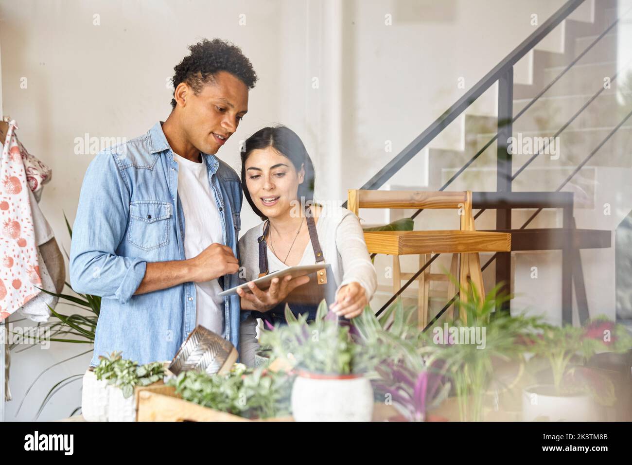 Coworkers using digital tablet at small business plant shop Stock Photo
