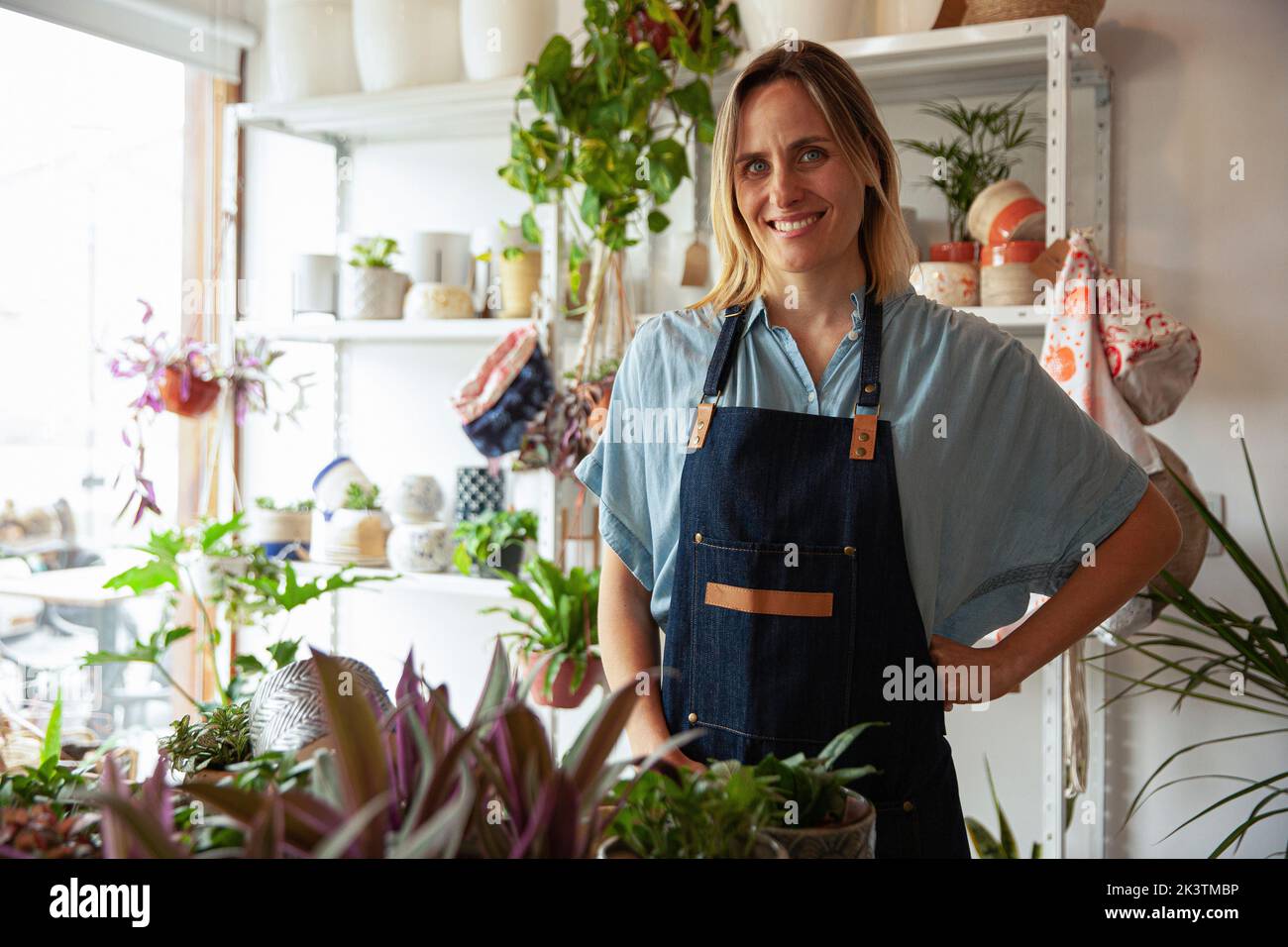 Adult plant store worker wearing apron while looking at the camera Stock Photo