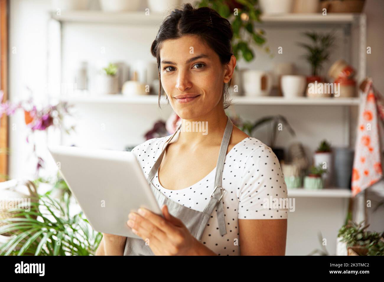 Young adult female nursery worker holding digital tablet Stock Photo