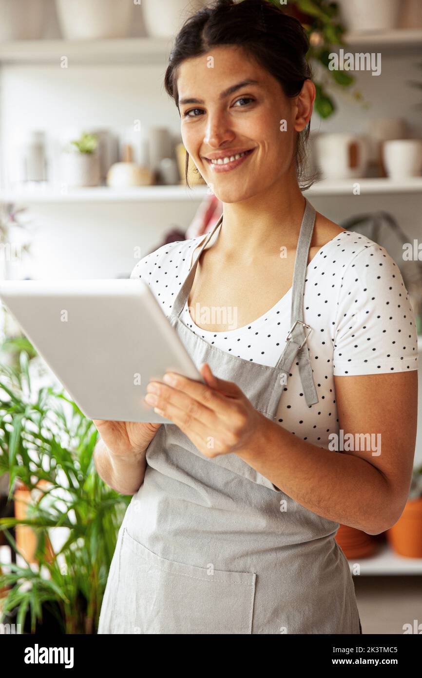 Young adult female nursery worker holding digital tablet Stock Photo