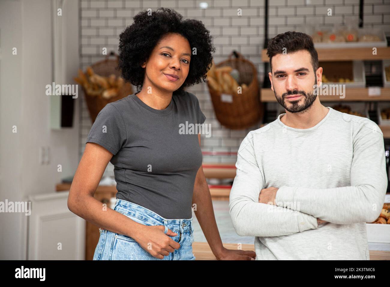 Pastry owners standing indoors looking at the camera Stock Photo