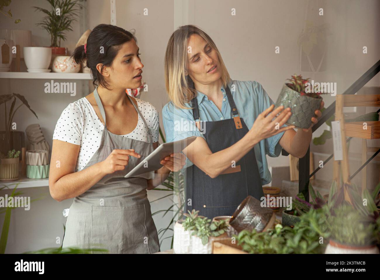 Flower shop owners setting prices in online store on digital tablet Stock Photo