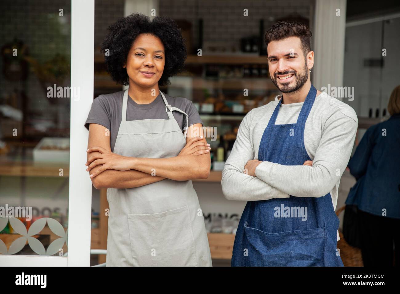 Bakery owners wearing apron standing with arms crossed Stock Photo