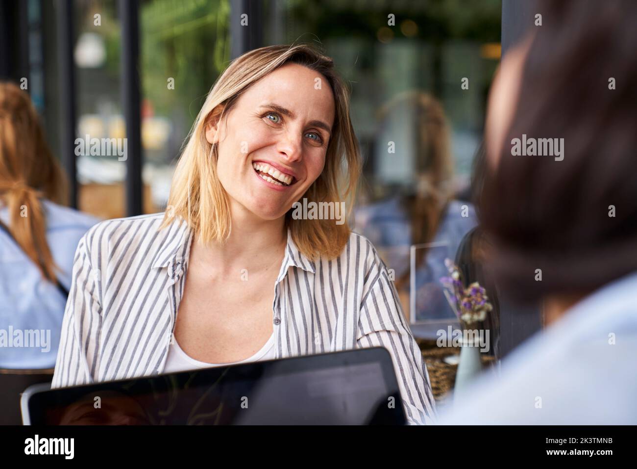 Front view shot of amused female entrepreneur having a good time while working in outdoors office with partner Stock Photo