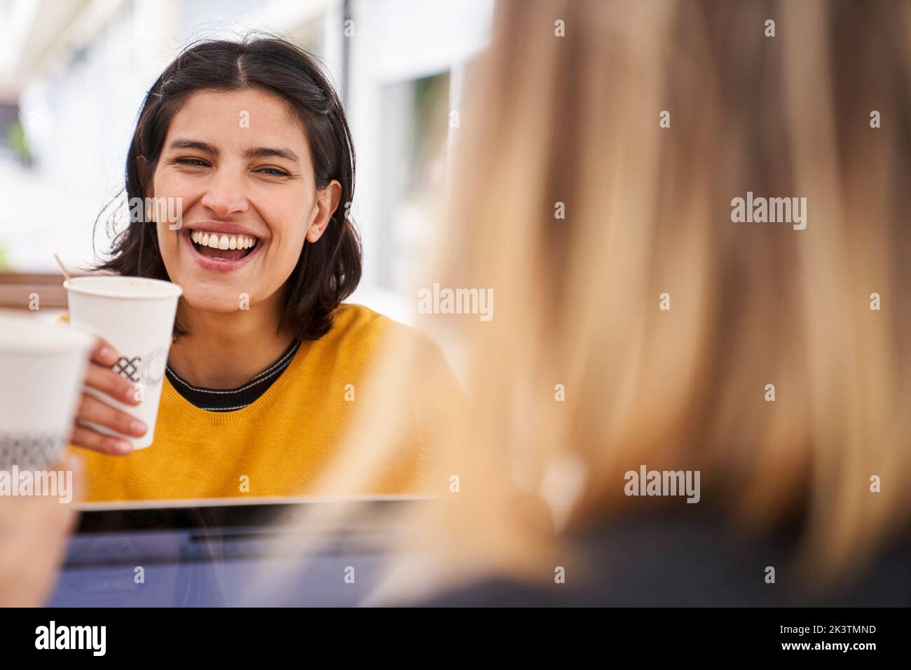Mid-shot front view of Latin-American businesswoman laughing with her co-worker Stock Photo